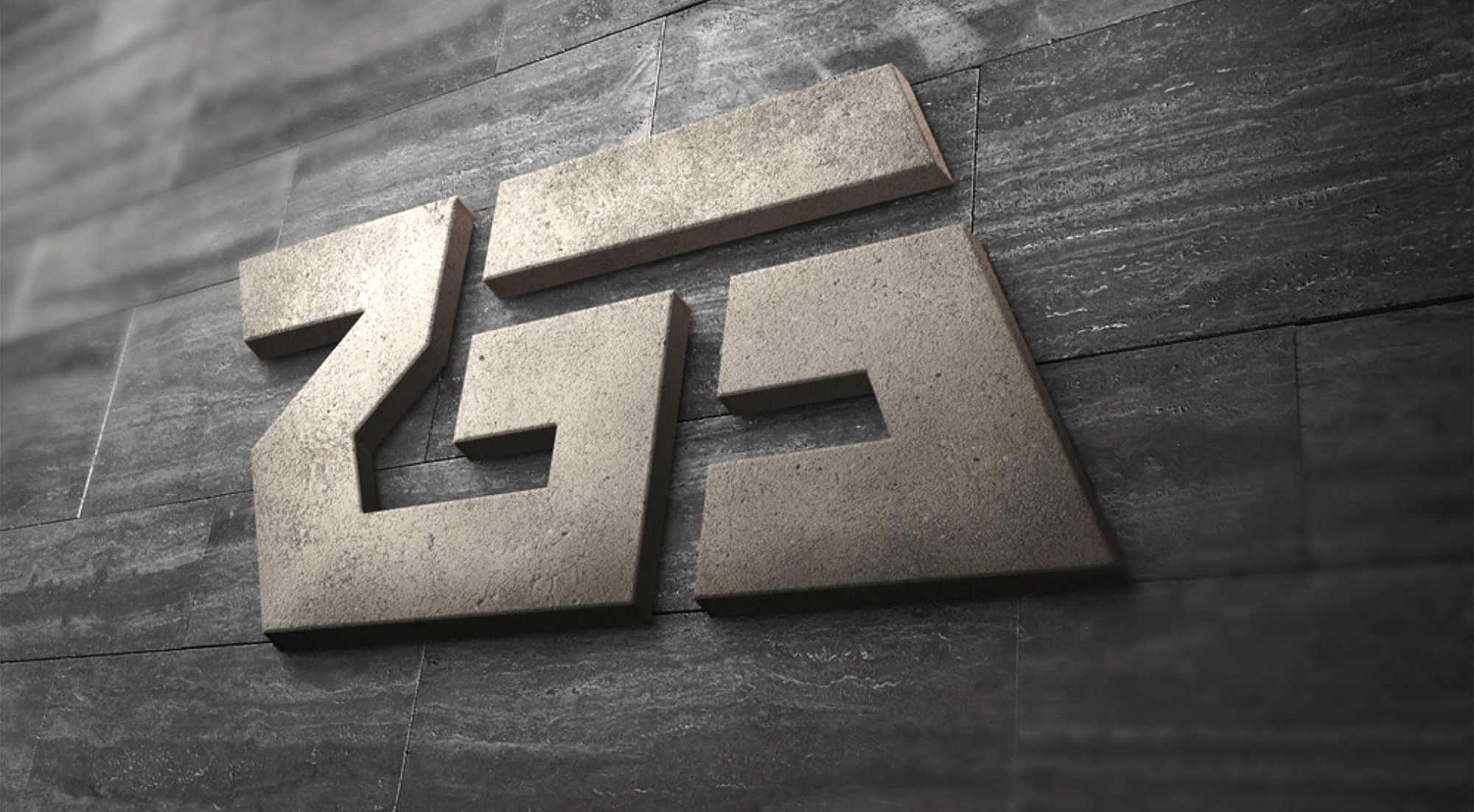 The monogram as dimensional concrete signage mounted on a dark slate wall