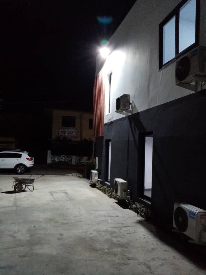 5AAP — the side elevation after dark under a single floodlight, a vehicle and wheelbarrow parked on the concrete yard