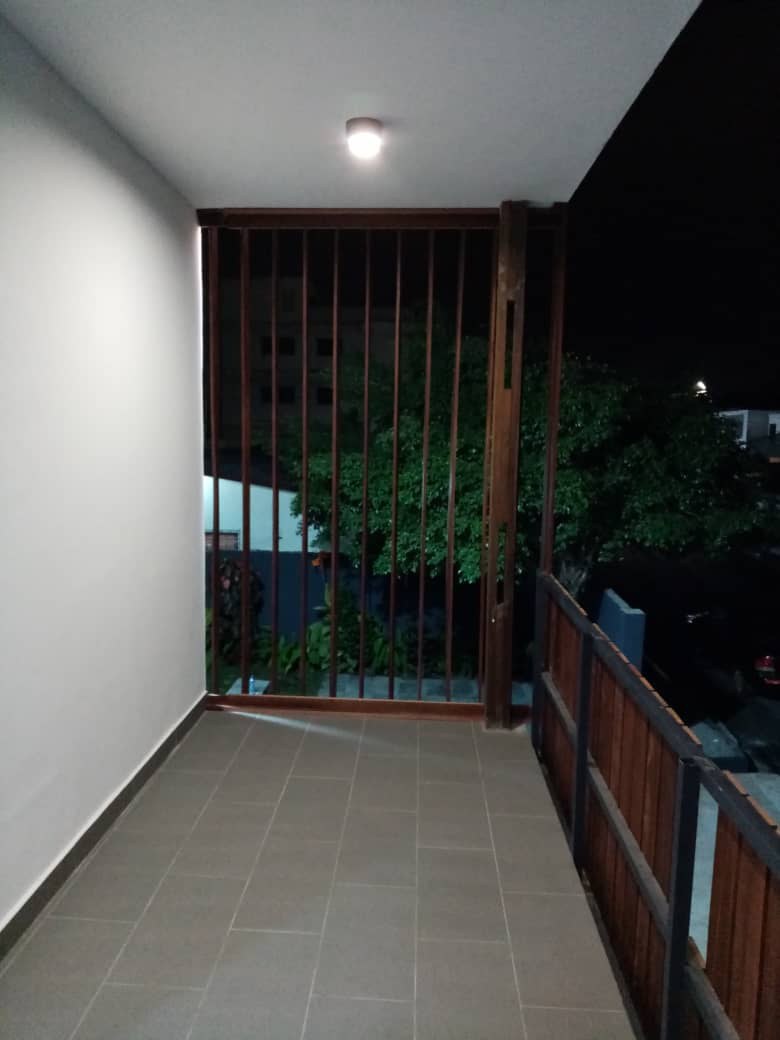5AAP — the balcony at night, battens and metal balustrade complete against the open yard