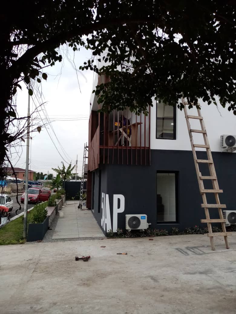 5AAP — the corner from the street under overhanging branches, the ladder still leaning on the finished elevation
