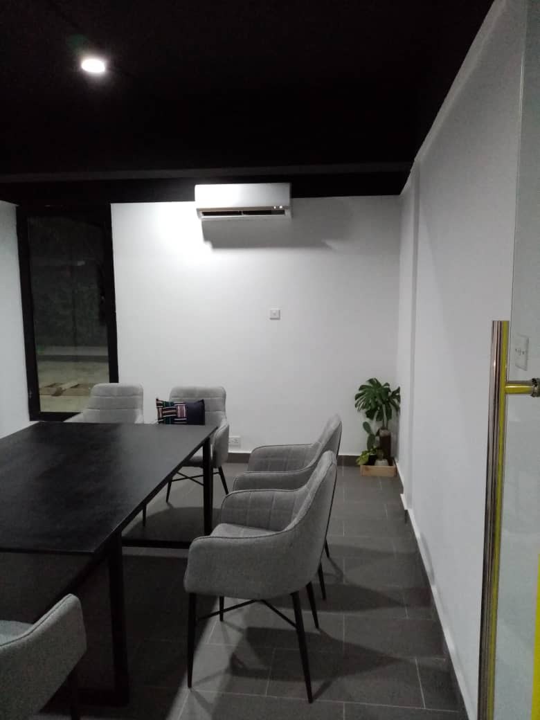 5AAP — the second meeting room under a black ceiling, grey upholstered chairs drawn in to the long table