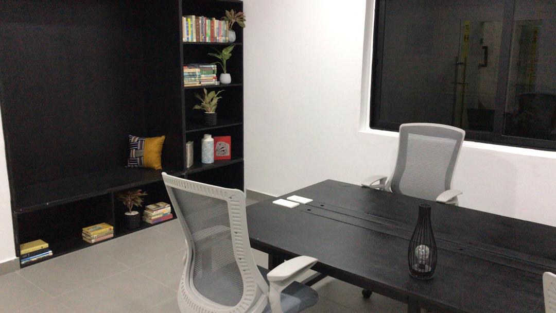 5AAP — the meeting room: a long dark timber table with white-framed mesh task chairs against a black wall and full-height shelving