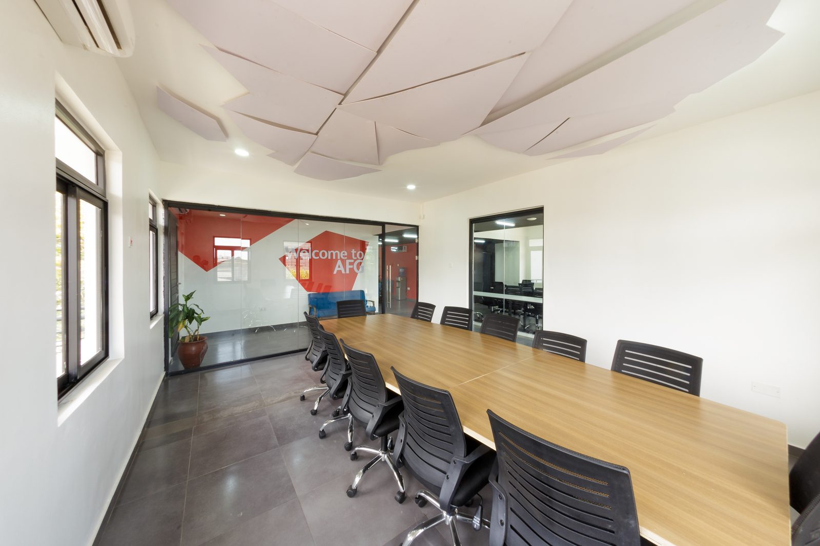 AFG - The table from mid-room, the graphic wall and lounge sofa visible through the glass.