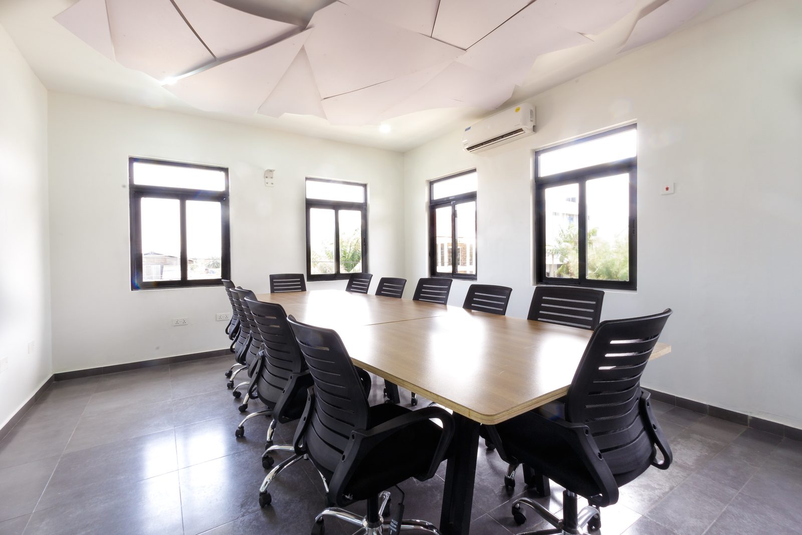 AFG - The boardroom from its short end, the table receding under a band of tall windows.
