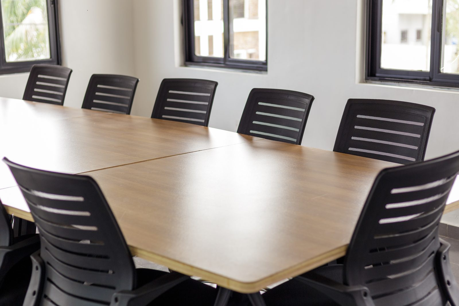 AFG - A close run of chairs along one side of the table, the joint in the plywood top visible.