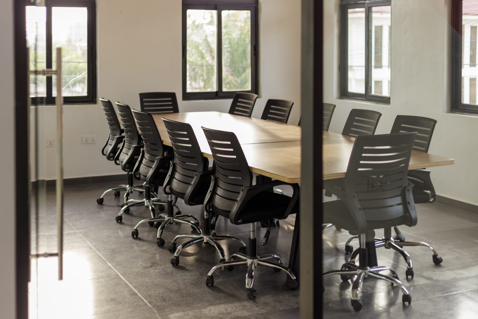 AFG - The boardroom seen through its part-open glass door, the table angled away from the camera.