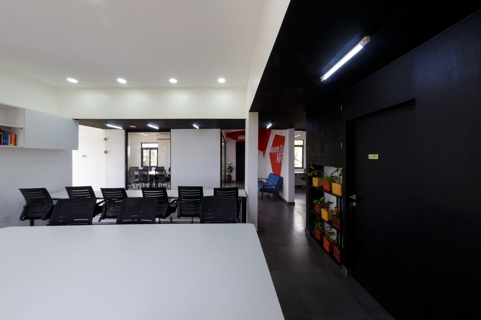 AFG - The workspace in low light, black-painted walls and doors absorbing the daylight off the desks.
