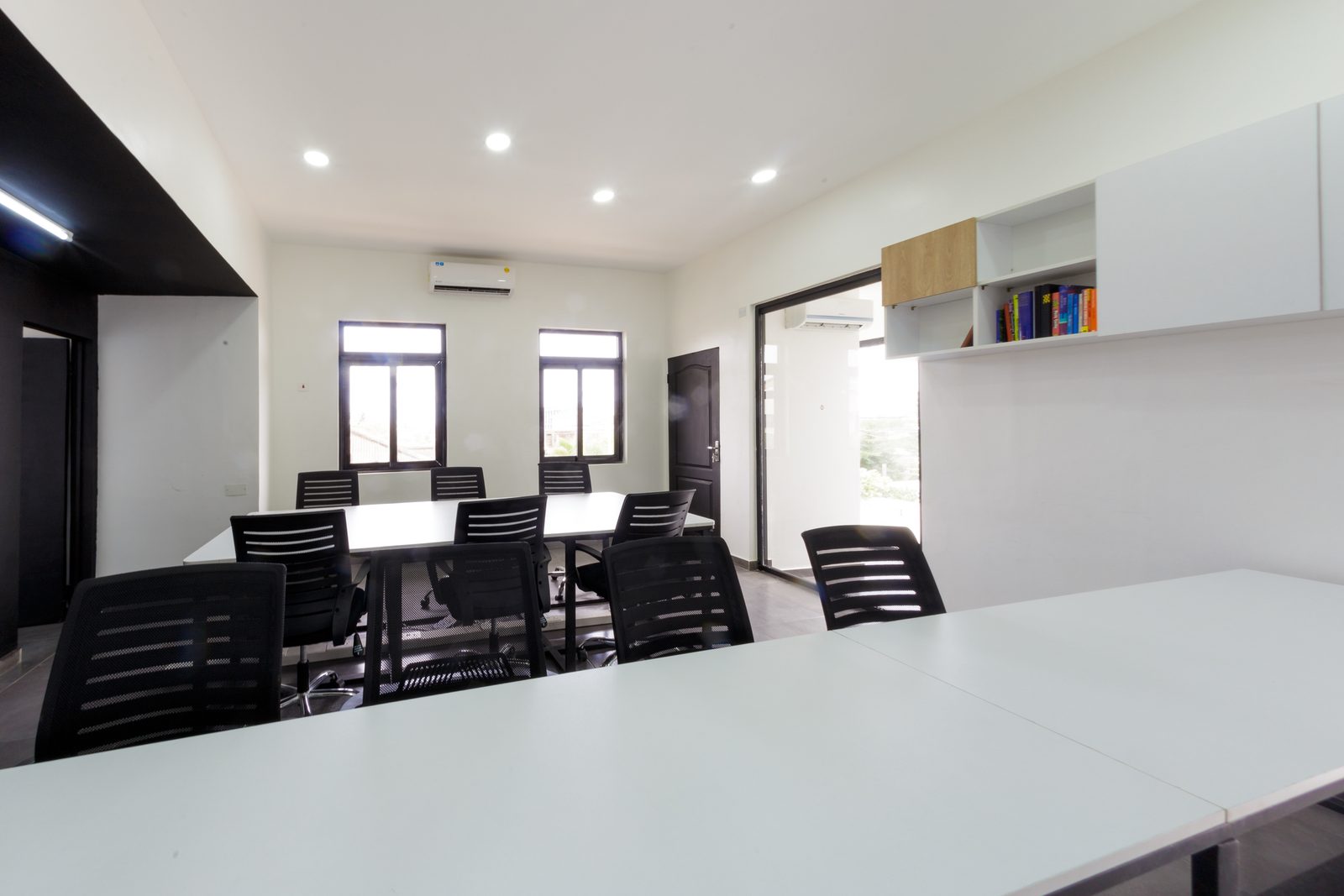 AFG - A corner of the open plan with wall-mounted shelving and a glimpse of the lounge seating.