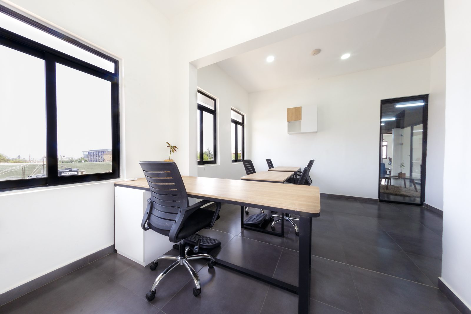 AFG - The same room from the window, desk and chair framed against the opening to the rest of the office.