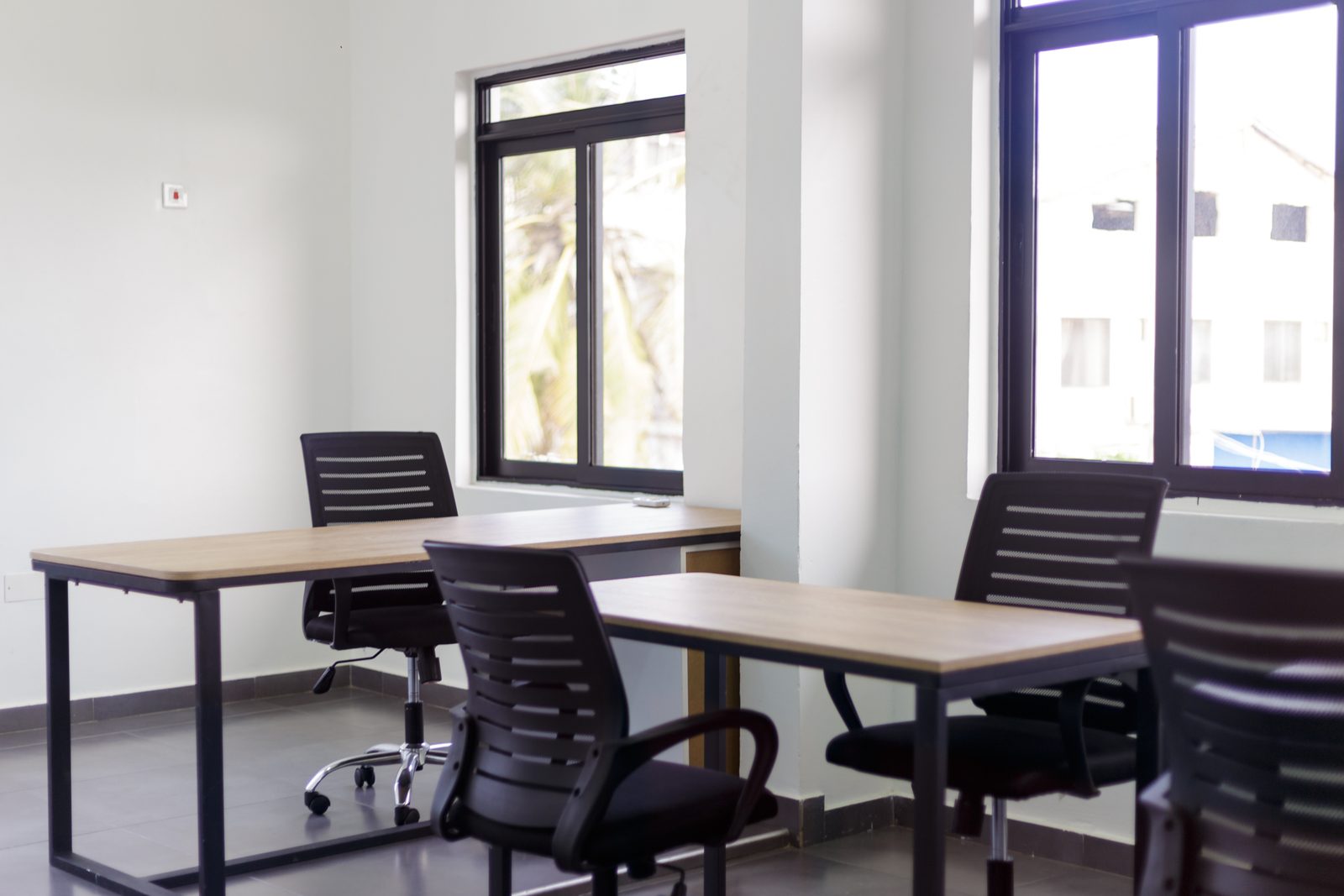 AFG - A desk and chair pair against a pair of tall windows looking out over the compound.