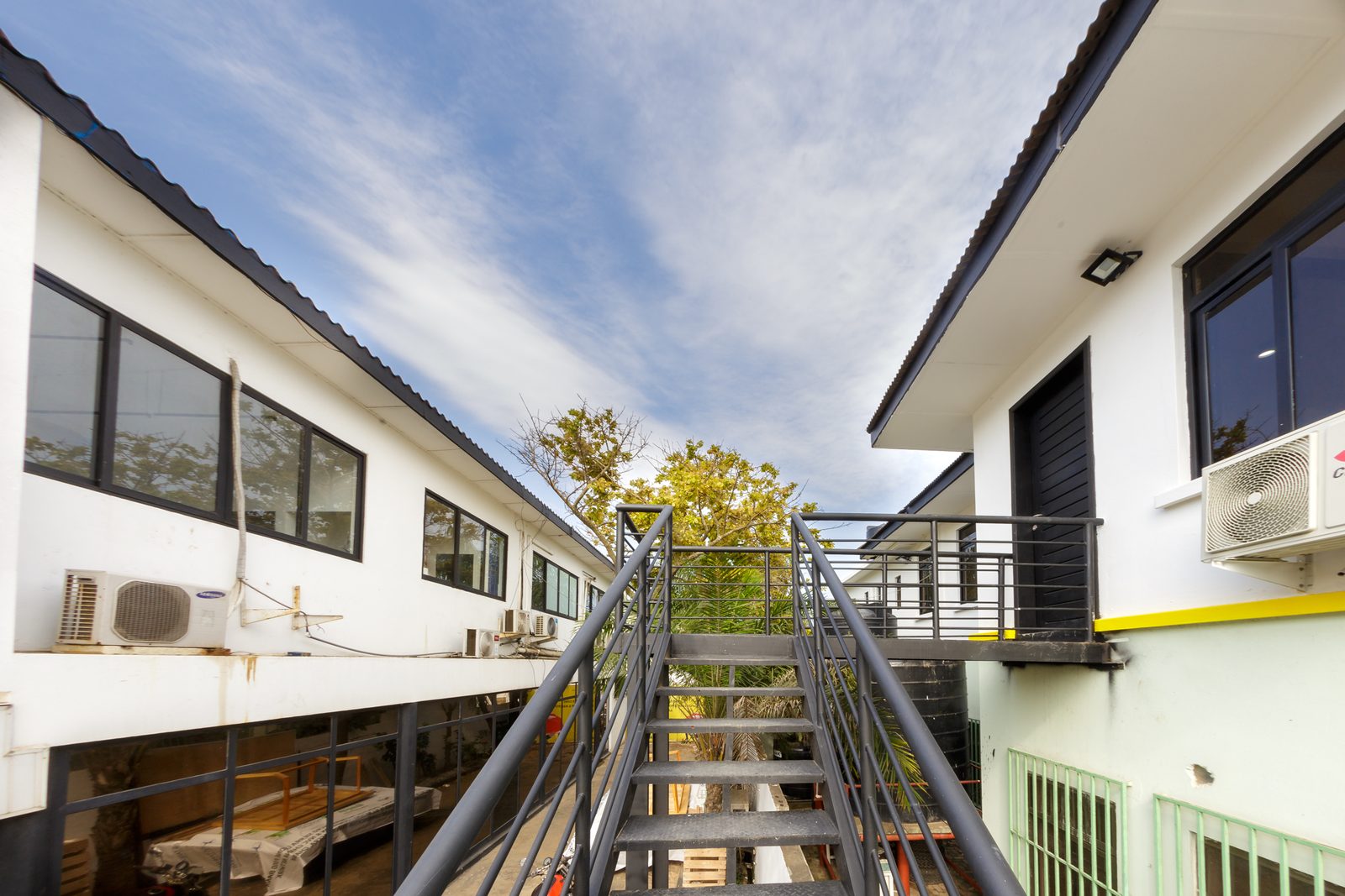 AFG - The long elevation of the block, windows and air-conditioning units under a pitched roof.