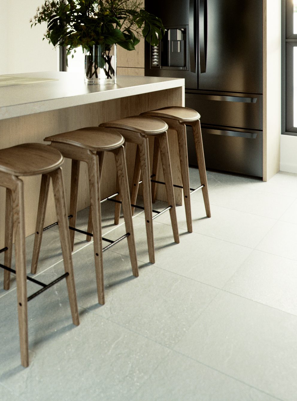 Detail of the breakfast bar: four oak stools tucked under the stone counter, a vase of greens on the island and the black fridge behind.