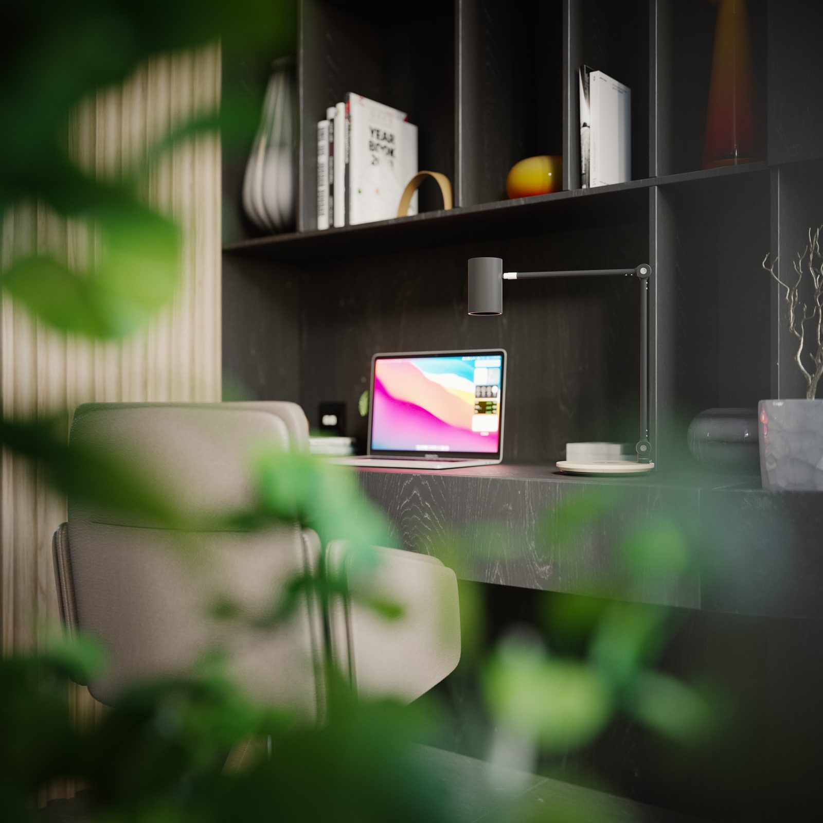 A study nook framed through out-of-focus foliage: a dark joinery desk with a laptop and a task lamp, open shelving above carrying books and ceramics, and the timber slat wall behind.