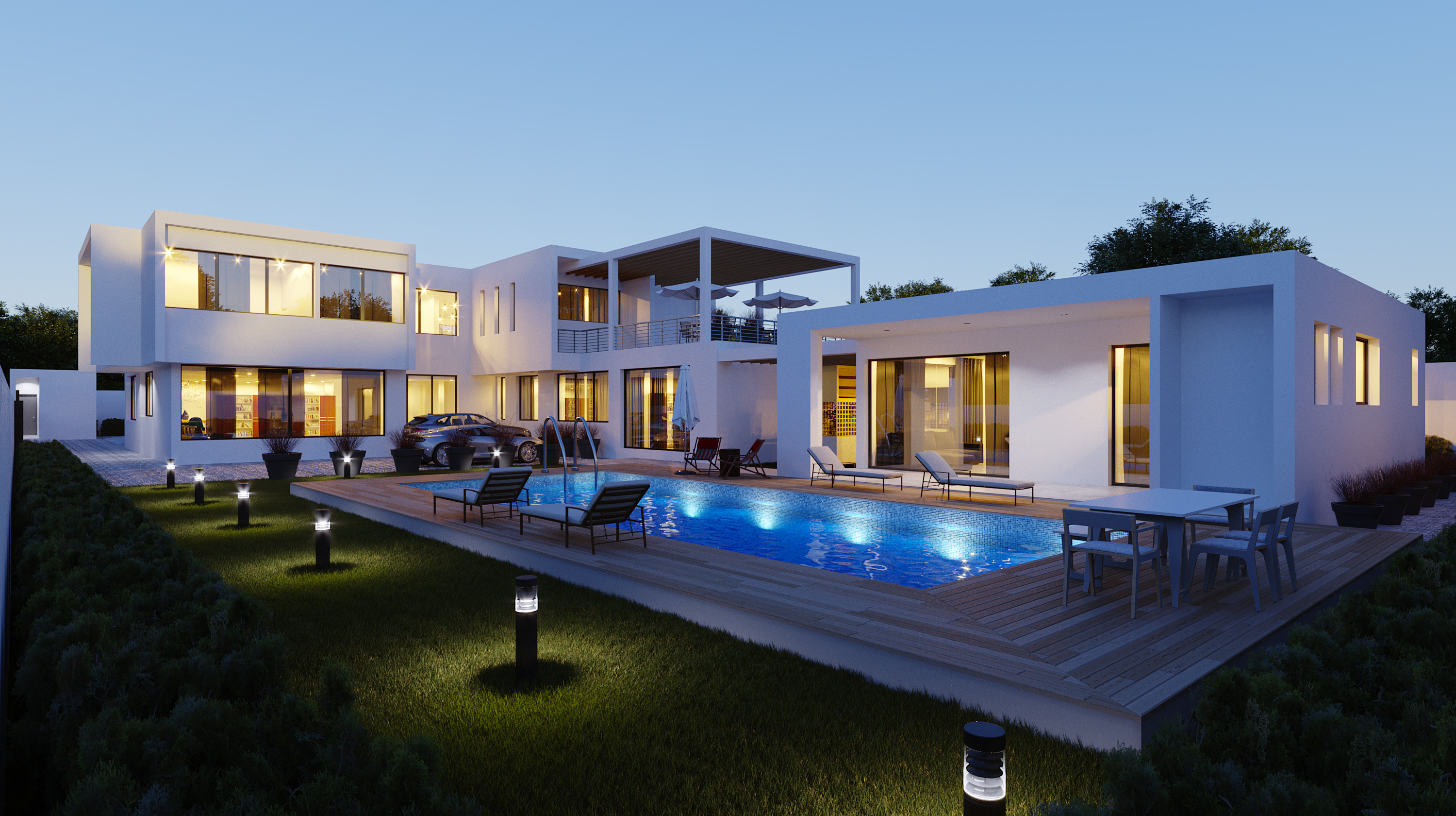 Airport Hills Residence at dusk, seen across the lawn: the white main house to the left, its pergola-capped terrace in the centre and the detached single-storey block lit to the right.