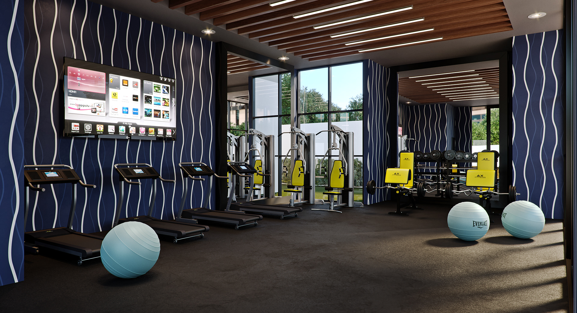 West Cantonments Residence gym from an interior corner: four black treadmills and yellow-cushioned AX FITNESS machines on dark rubber flooring, three blue EVERLAST balance balls, a wall television showing an input menu and a wood-slat ceiling with linear LEDs.