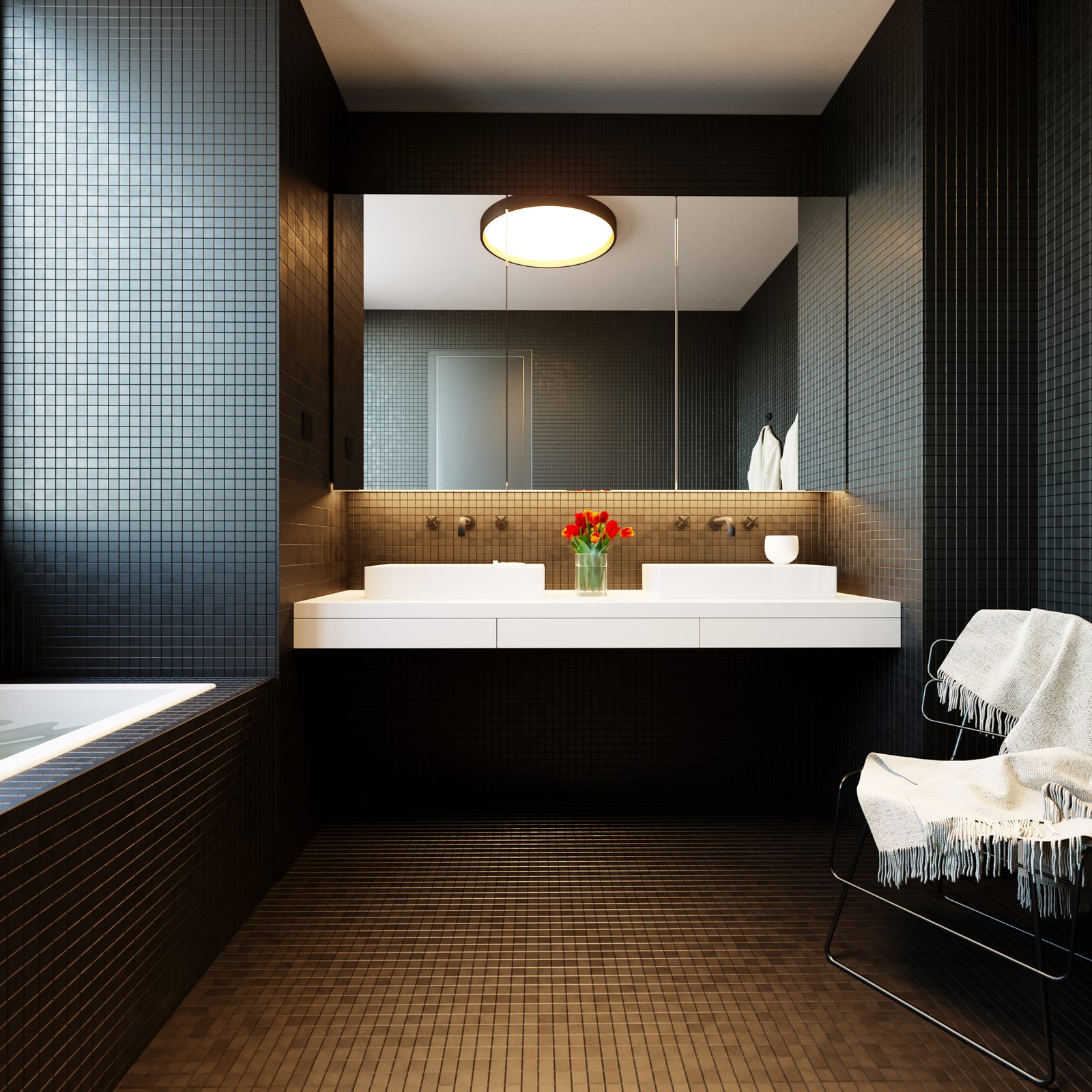 Tower Cascades - Principal bathroom, square crop: a double vanity with two vessel basins under a wide mirror and a round backlit mirror, dark mosaic tiling and a wire chair with a thrown towel.