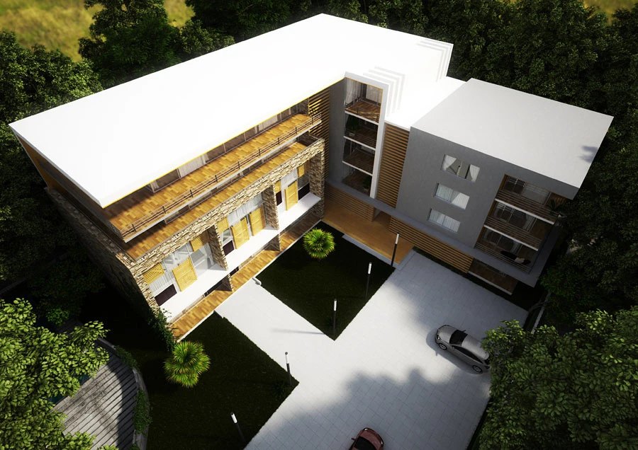 Aerial render: the U-shaped apartment complex seen from above, white roofs over stone and timber facades, a courtyard lawn and a parked car framed by dense green trees.