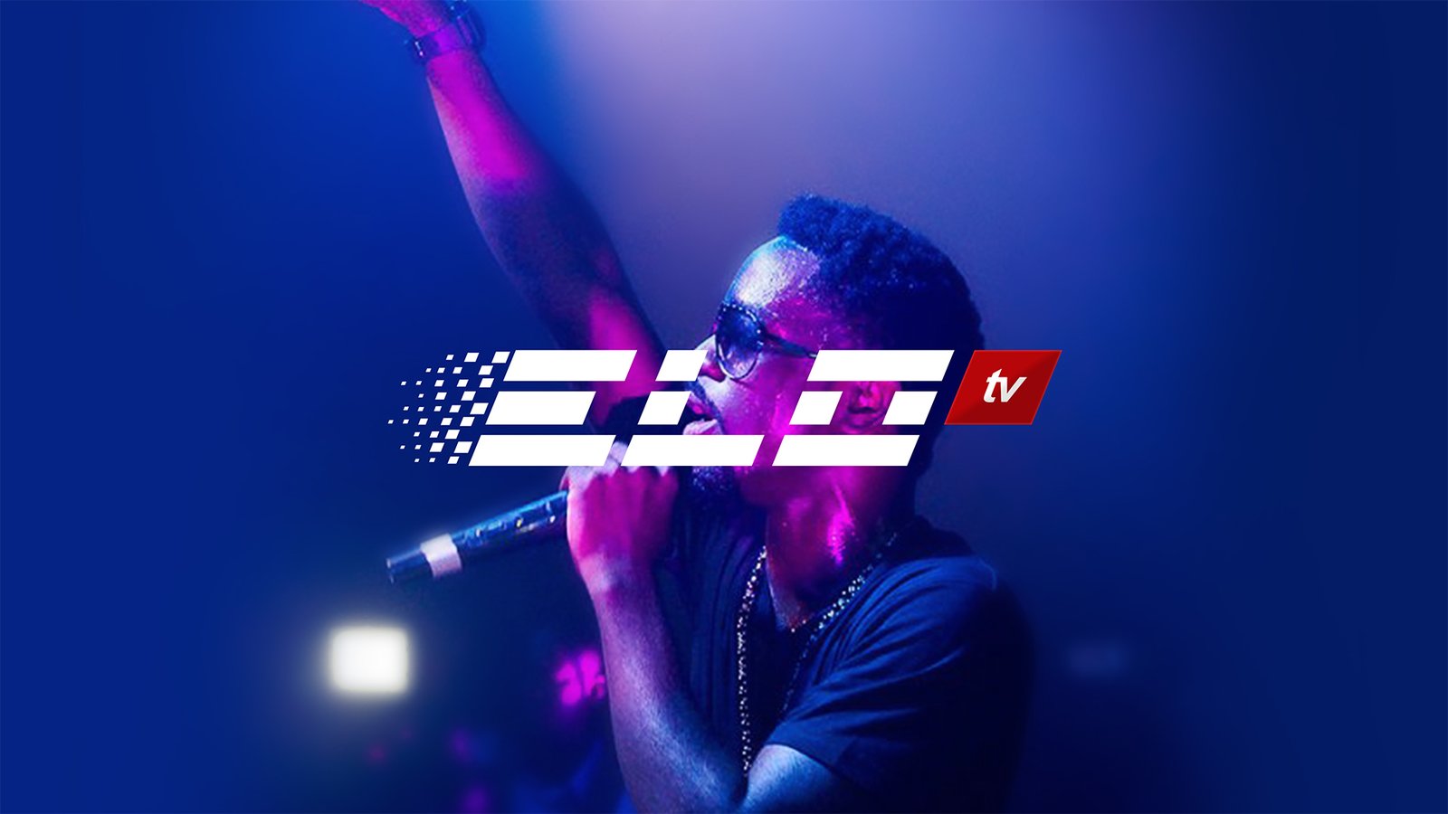 ELO TV logo overlaid on live footage: a white letterform lock-up across a singer with one arm raised, sunglasses and a microphone in hand, washed in blue and magenta stage light.