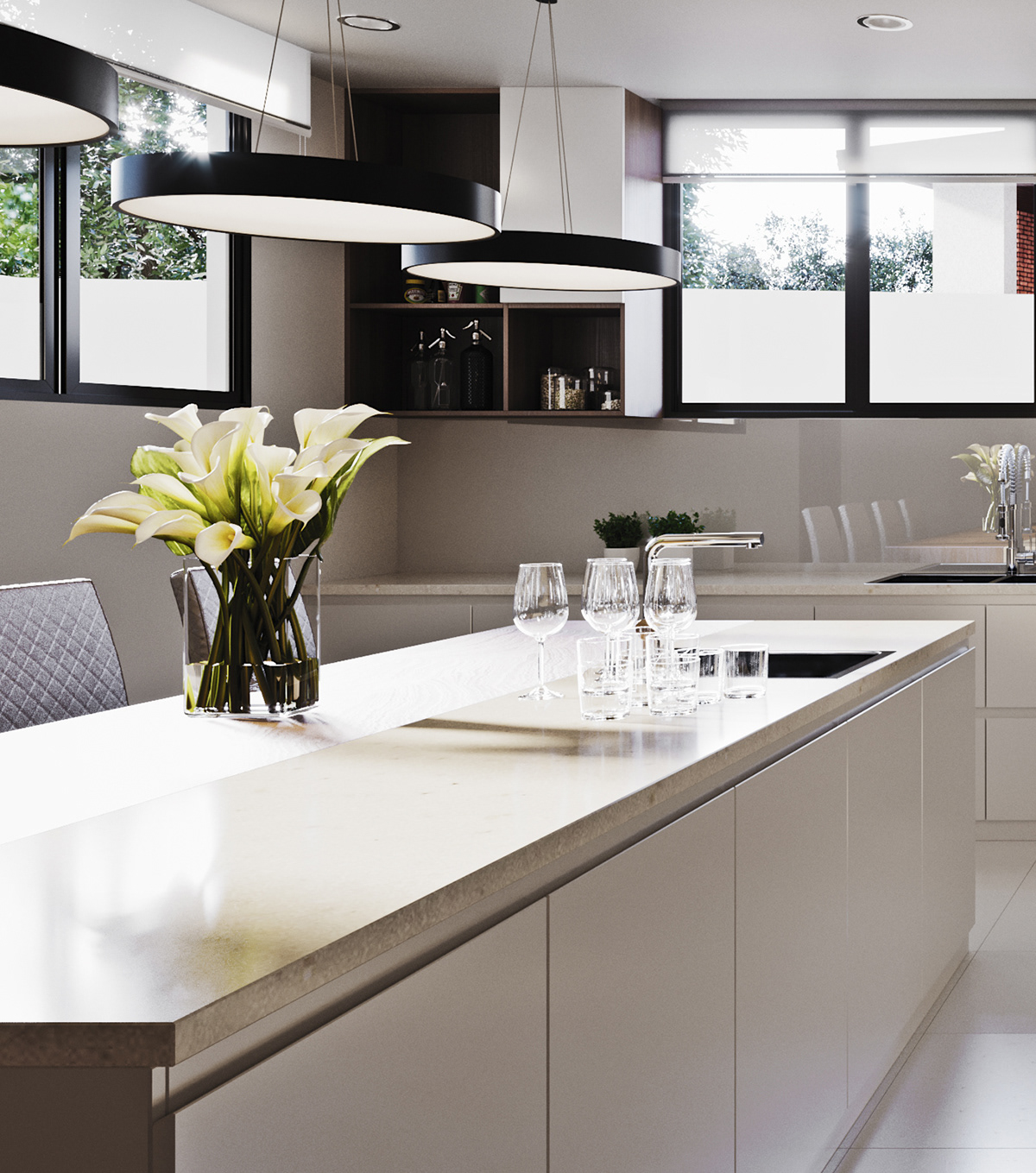 Funko Ridge Residence island and pendant cluster: white calla lilies and tumblers on the pale stone top, black ring lights overhead and a niche of bottles and jars at the rear.