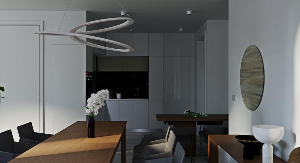 Giffard Park dining room: two oak tables with grey chairs under a sculptural white ribbon-ring pendant, a dark glossy kitchen with built-in ovens behind and a round mirror on the right wall in low raking light.