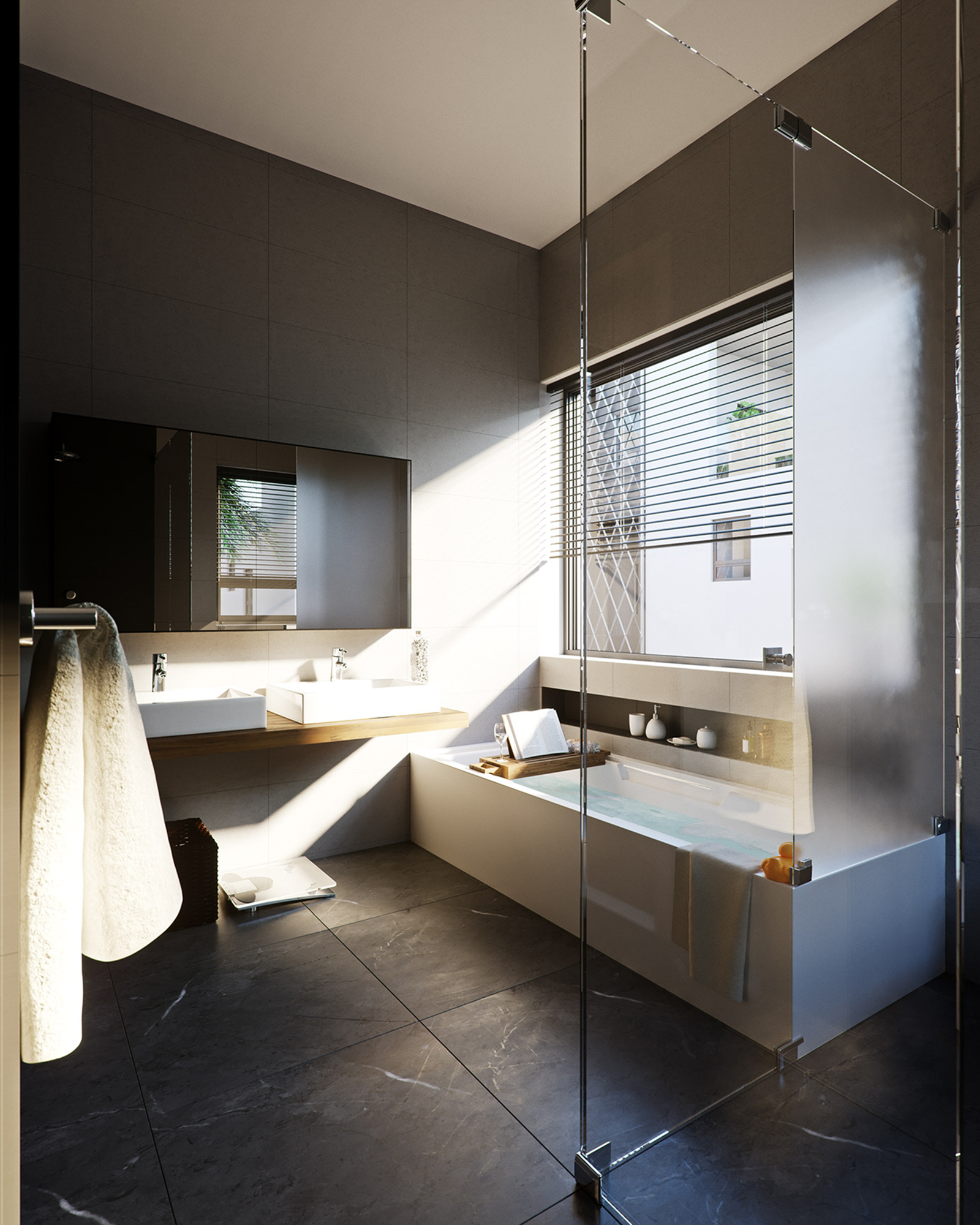The Hamlet bathroom: two white vessel basins on a floating oak shelf beneath a mirror cabinet, dark grey large-format wall tiles, a built bath under a blind-dressed window with a tray holding a book and a glass, and a frameless glass shower screen in the foreground.