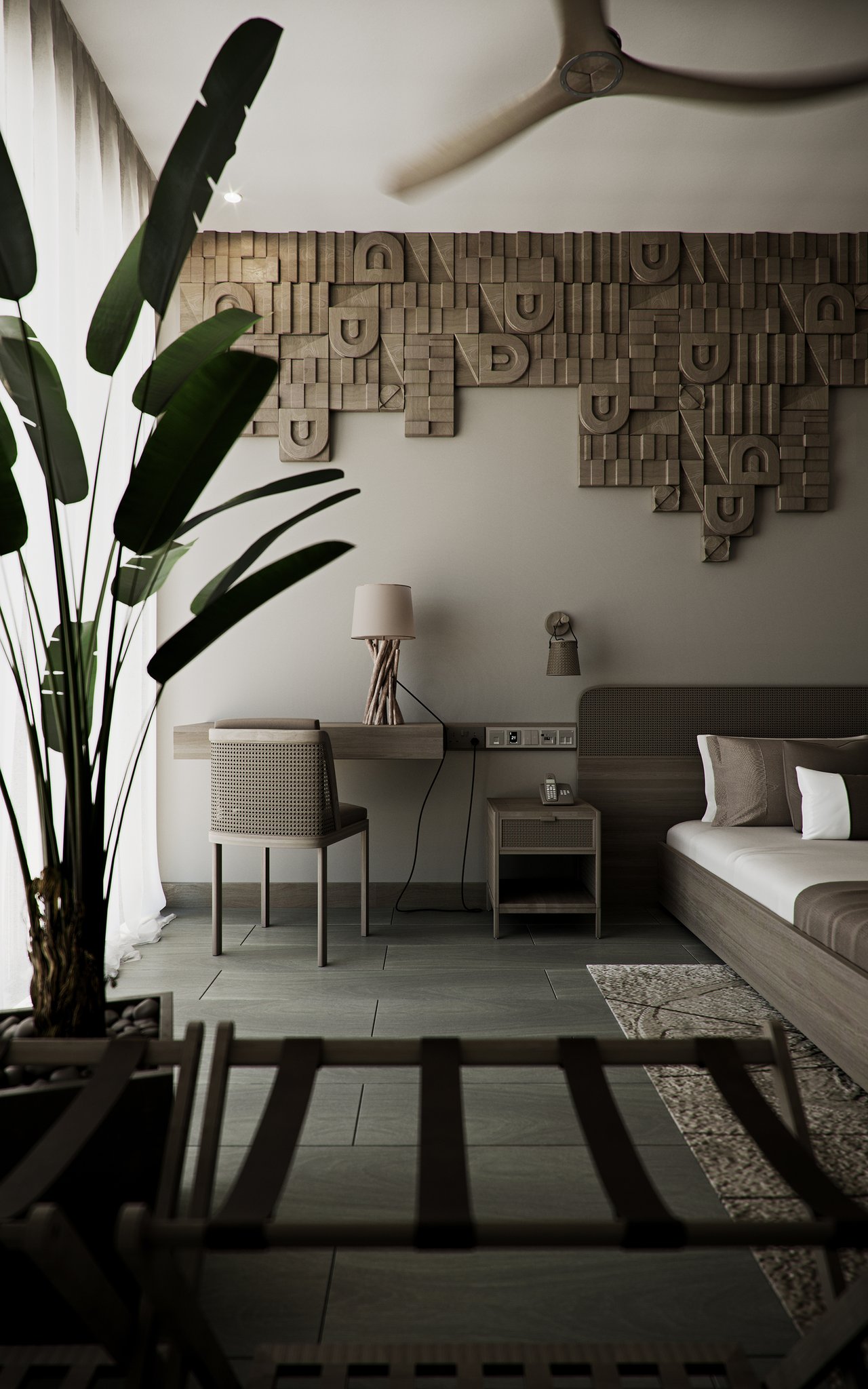 HGG writing corner: a wall-hung oak desk with a branch-base lamp and cane chair beside the nightstand and telephone, the geometric timber relief above and a tall bird-of-paradise plant at the window.