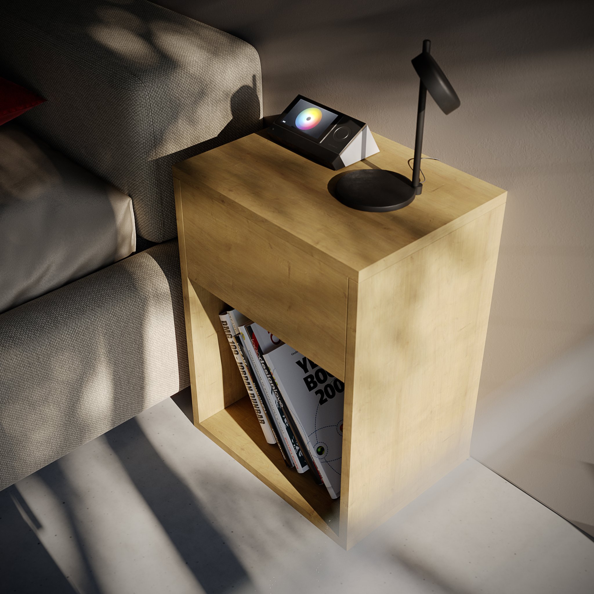 Hola - the oak nightstand seen from above beside the grey sofa, its colour-wheel panel and black lamp on top and a shelf of design books below