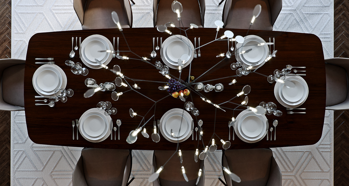 Link Drive Rd. dining table from directly above: eight places of stacked white plates and laid cutlery on the dark walnut top, a bowl of fruit at the centre, the branching light fixture's arms and mirrored discs spreading across the frame over grey chairs and the pale geometric rug.