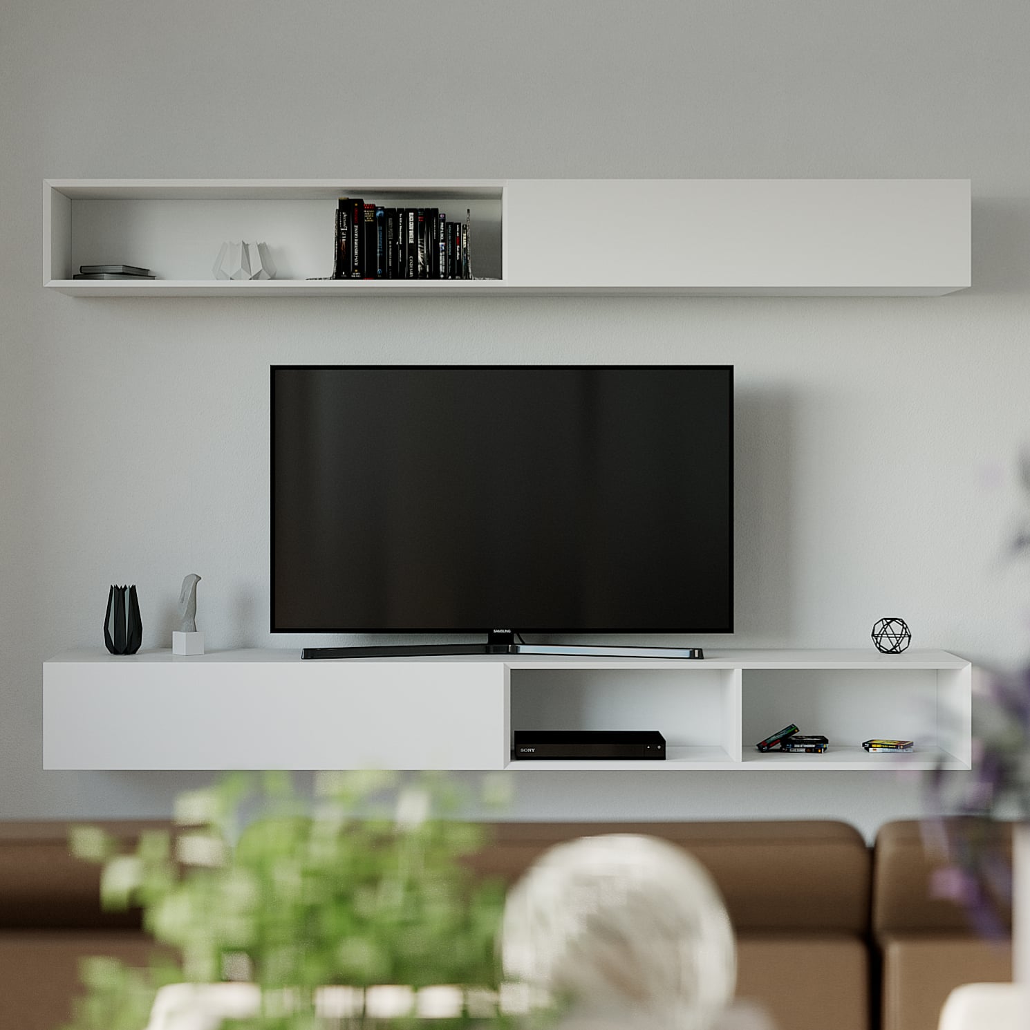 MIG Line E Float I straight onto the wall: a white floating media unit with a recessed upper shelf of cases and discs, a Samsung flat screen standing on the lower cabinet, a brown sofa back and blurred plant in the foreground.