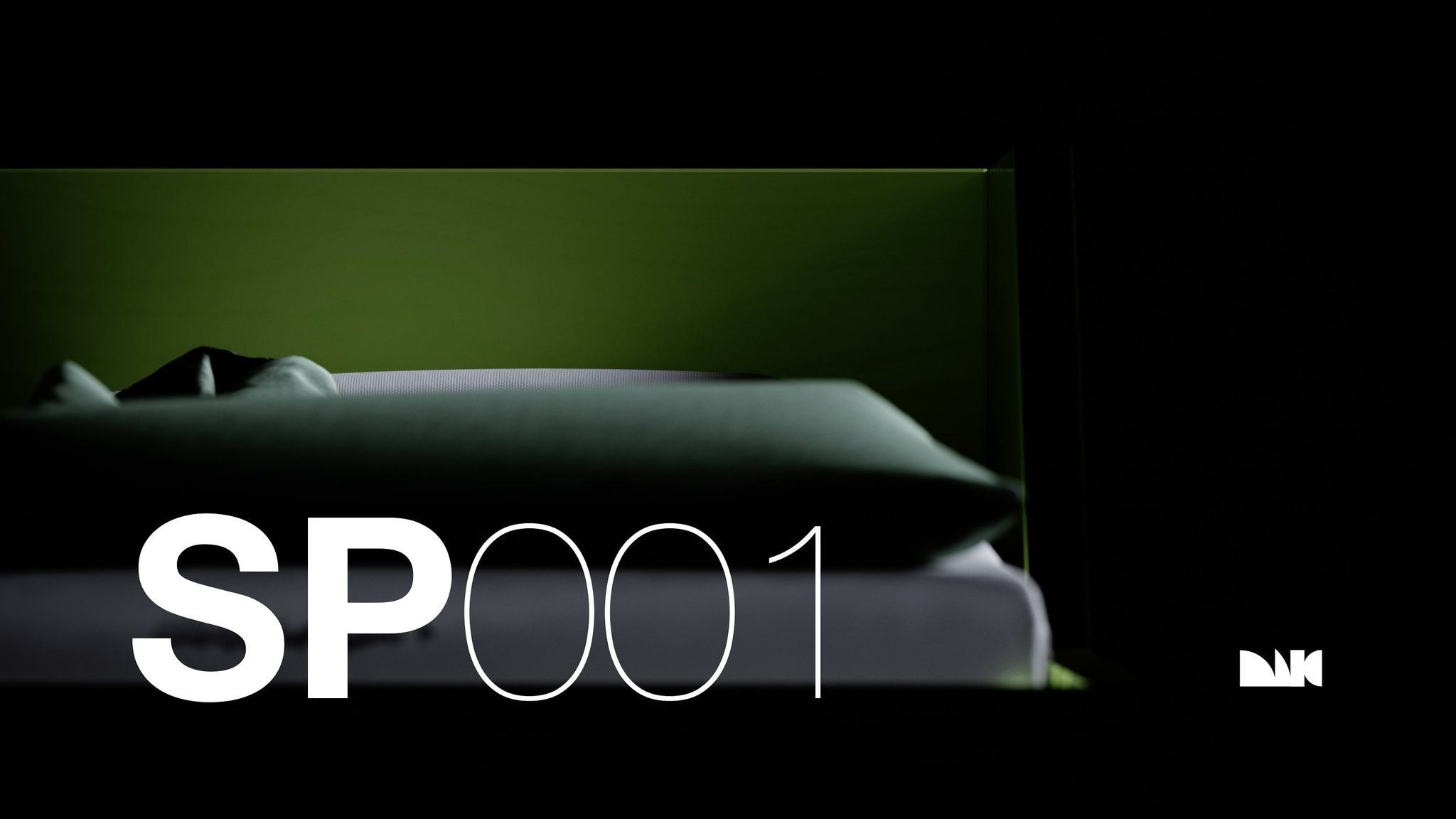 MIG SP001 pod interior in low close-up: a green-lit back panel behind a dark pillow and the edge of a white mattress, the surround falling to black, titled SP001.