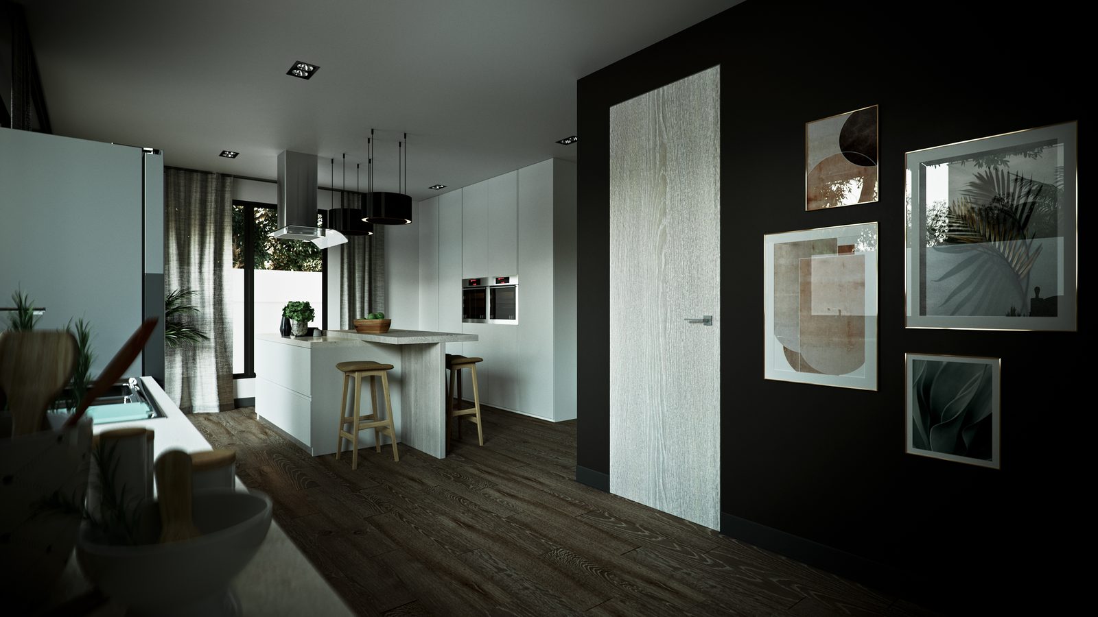 The kitchen from the dining side at night: the island under the pendant cluster, the black feature wall and its framed prints to the right.