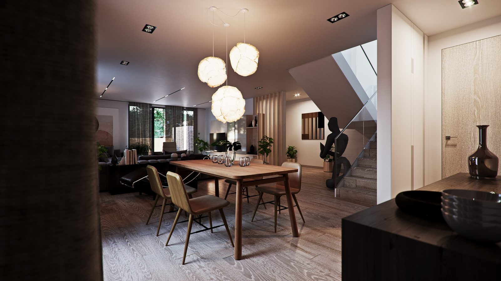 Dining table seen through the living room at night, paper pendants lit and a sculpture on the half-landing.