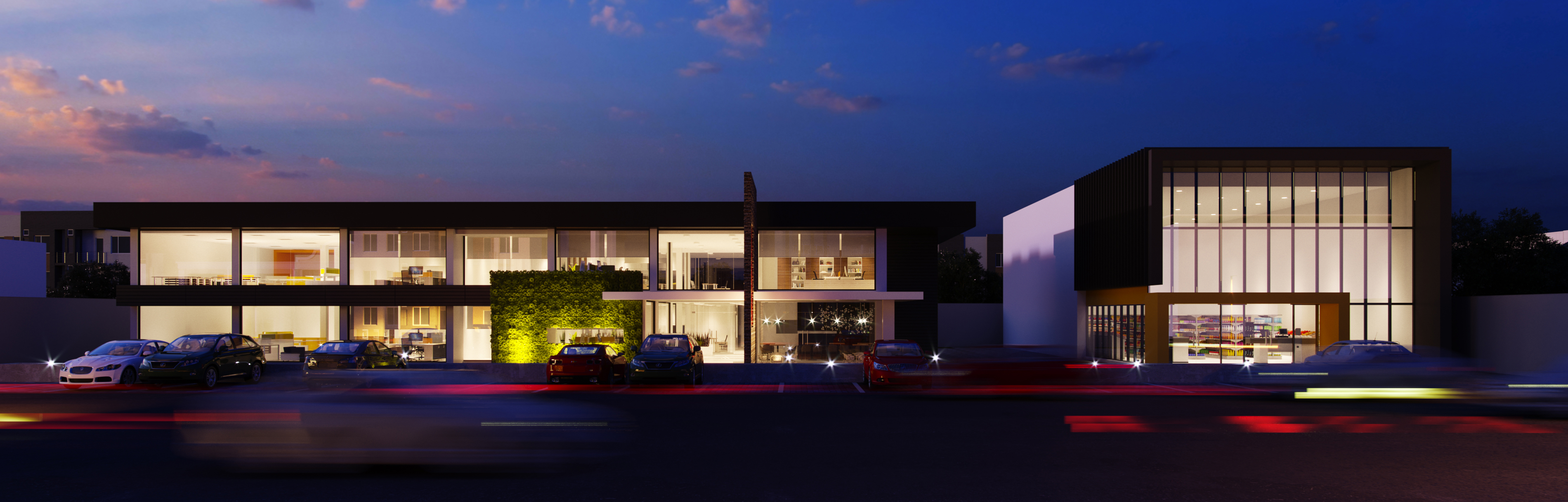 Palazzo at dusk, seen across the road: a two-storey glazed office block lit warm inside beside a taller black-framed retail pavilion, a planted wall uplit at the centre, cars parked along the front and red and white light trails streaking the foreground under sunset cloud