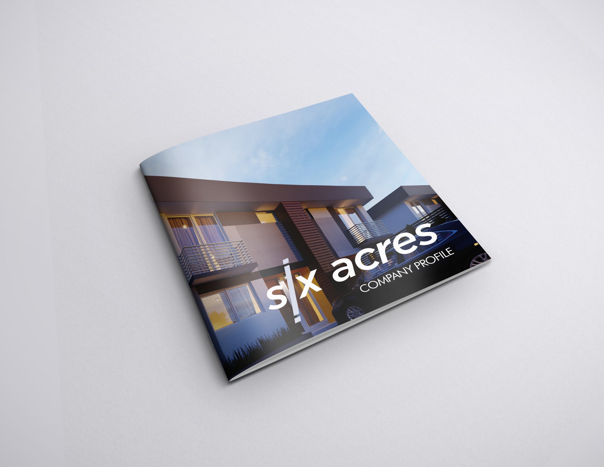 The finished profile lying on a pale grey ground: a dusk render of a two-storey house with lit windows and a deep eave wraps the cover, the six acres wordmark set in white with the i drawn as a full-height vertical stroke above the words COMPANY PROFILE